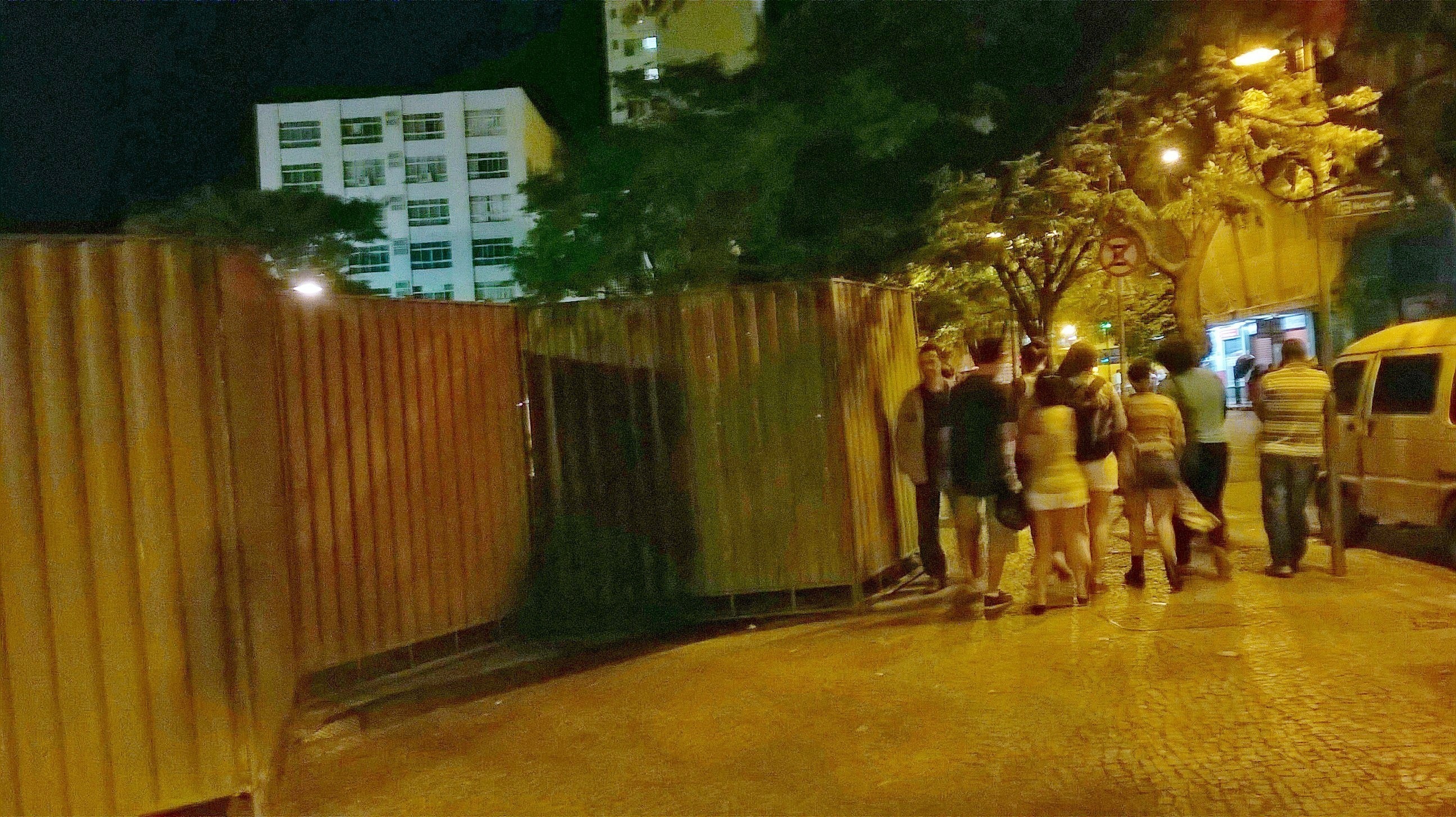 Do outro lado do tapume tem uma praça