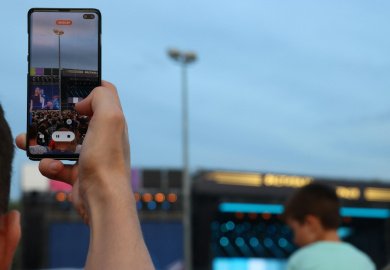 smartphone captando um palco de festival ao fundo