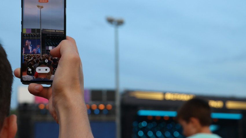 smartphone captando um palco de festival ao fundo